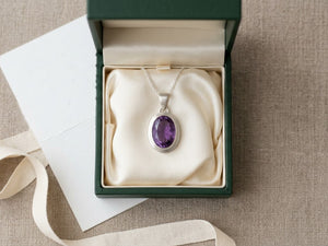 A finished silver amethyst pendant in a green gift box