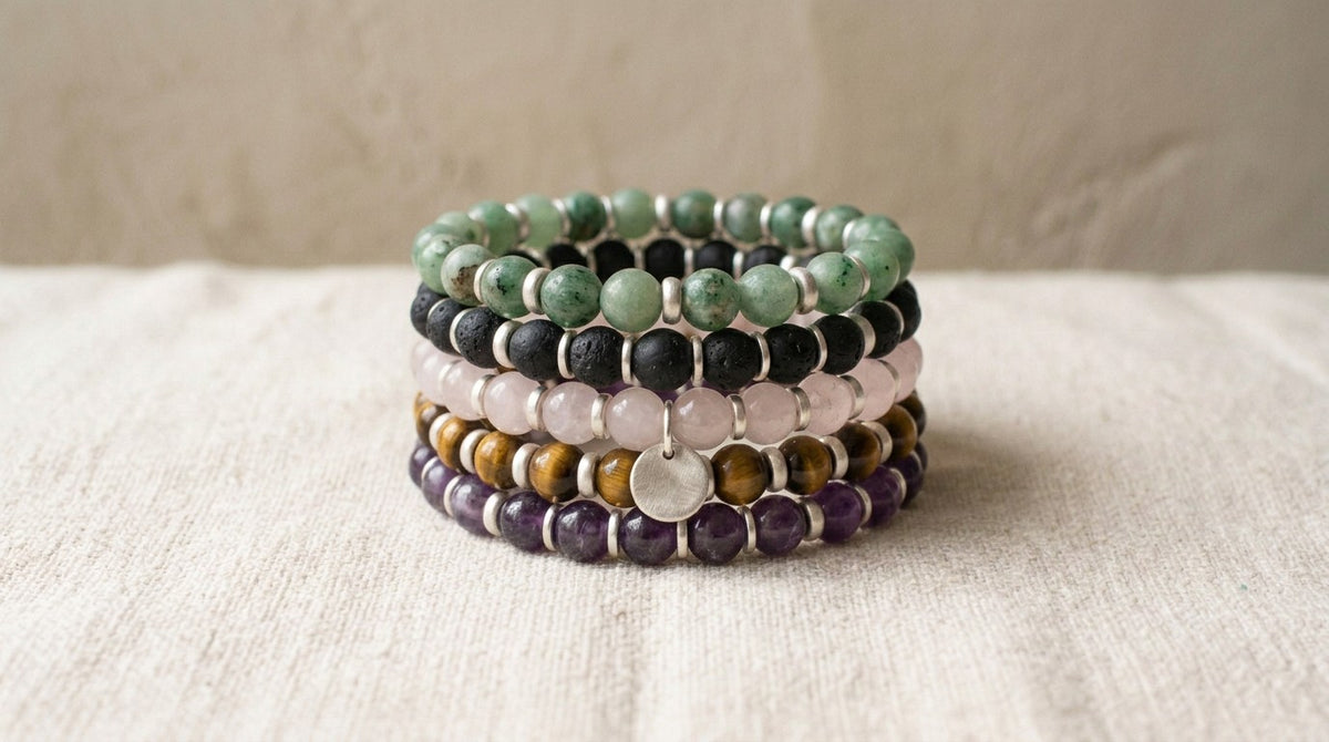 A stack of natural gemstone bead bracelets on linen